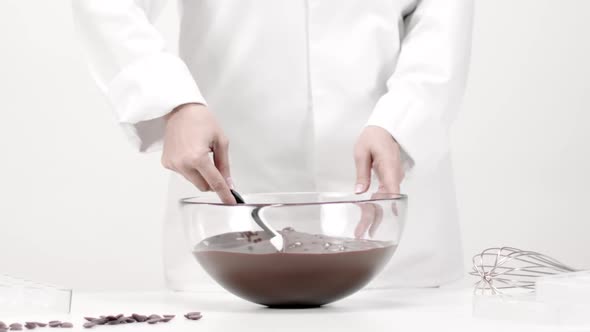 Mixing Delicious Melted Dark Chocolate with Silicone Spatula on White Background