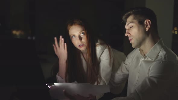 A Hardworking Woman Works Late at the Office with Colleagues alt