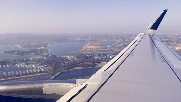 View over airplane wing looking out over San Diego leaving the airport alt