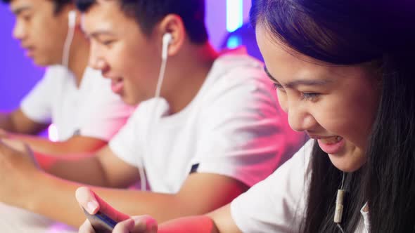 Close Up Team Of Asian Gamers Playing In Competitive Video Games By Mobile Phone alt