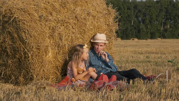 Little Girl with Father Sitting Near a Haystack alt