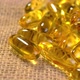 Golden fish oil capsules. O???? 3 supplement pills on a rustic textured burlap cloth. Macro - VideoHive Item for Sale