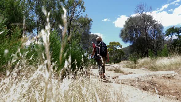 Woman with backpack on footpath in landscape, Victoria, Australia