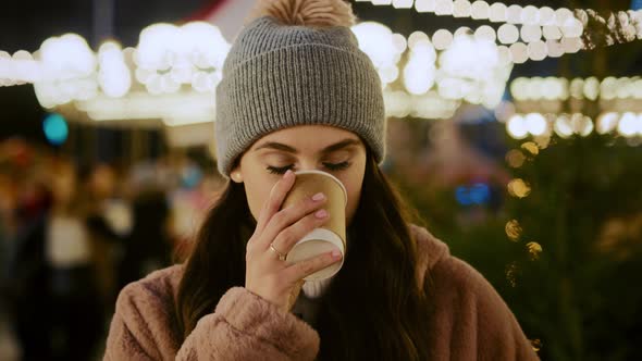 Portrait video of woman drinking hot chocolate on Christmas market alt