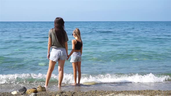 Beautiful Mother and Daughter on the Beach Enjoying Summer Vacation