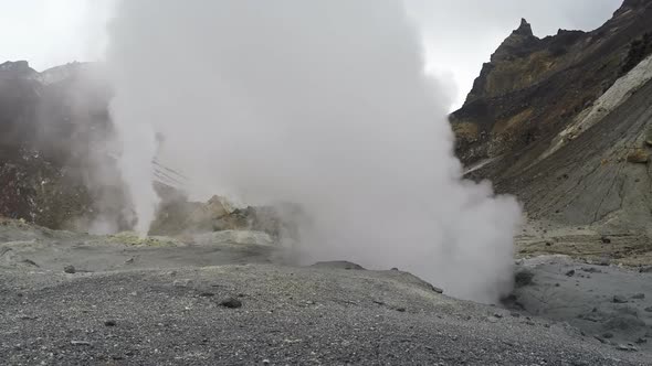 Smoking (steaming) fumarole on thermal field in crater active volcano