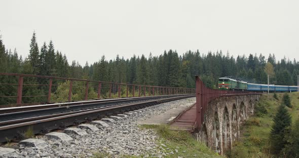 Train Goes Over the Bridge with an Old Stone Viaduct alt