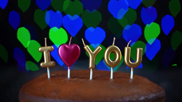 Video Shot of Simple Valentines Day Cake with Lit i Love you Candles with a Colorful Background