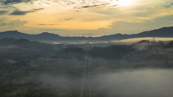 Aerial views, mountains and clouds with High-voltage power pole,
