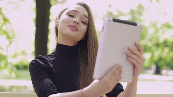 Young Smiling Woman Using Tablet for Online Conversation alt
