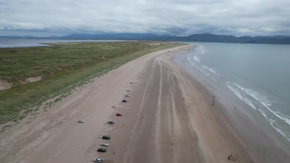 Row of cars parked on Inch beach Dingle peninsula Ireland drone aerial view alt