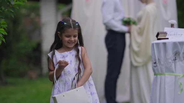 Medium Shot of Cheerful Beautiful Middle Eastern Girl Scattering Petals on Marriage Ceremony with alt