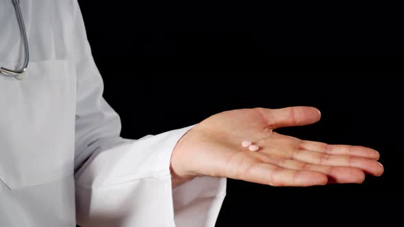 Cropped Shot of Doctor Holding Medical Pills in Hand alt