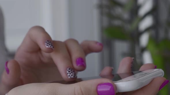 Manicured Female Hands with Stylish Pink Nails Holding Mobile Phone alt