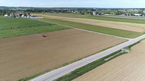 Aerial View of Amish Farm Worker Harvesting Spring Crop With Team of 6 Horses alt