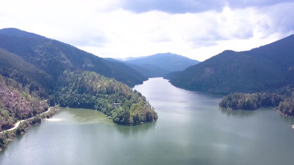 Aerial Drone Shot Following a River through the Romanian Mountains. alt