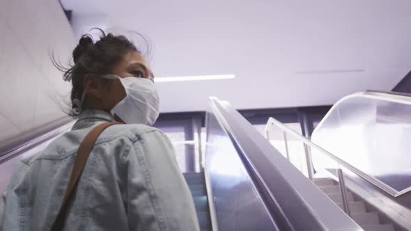 Mixed race woman wearing medical coronavirus mask on the street alt