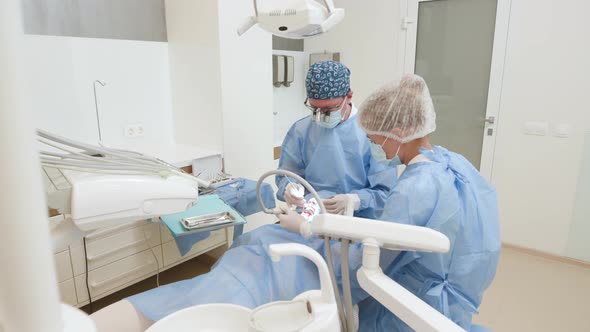 Professional Dentists Doctors Performing Dental Surgery in Patient's Oral Cavity for Treatment