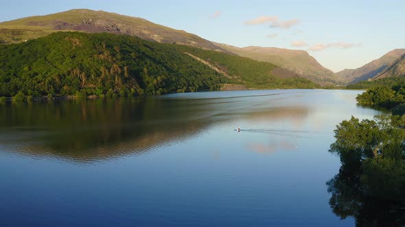 Tranquil Scene of One Boat on Lake at Snowdonia National Park in Wales - Aerial Drone alt