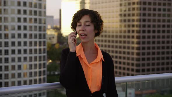 Businesswoman using cell phone on rooftop in city