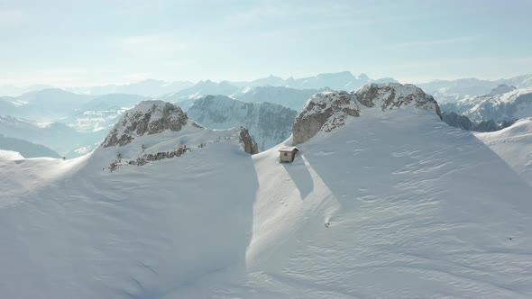 Flying of snow covered cliff and revealing beautiful valley alt