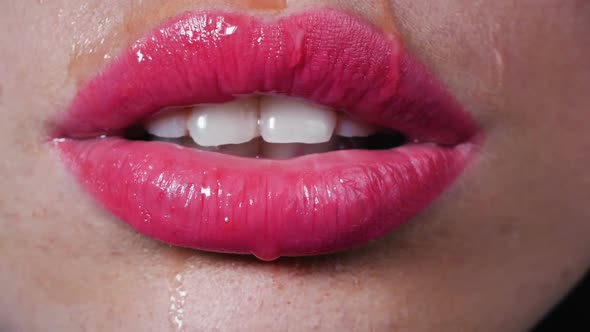 Water Drops Drip on Beautiful Female Lips, Сlose-up. Woman Seductively Licks Her Lips with Her