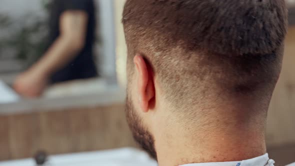 Barber Doing a Haircut to Male Client in Barbershop Close Up