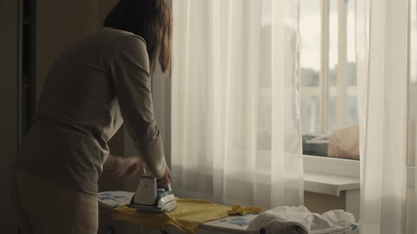 Young woman Ironing at home alt