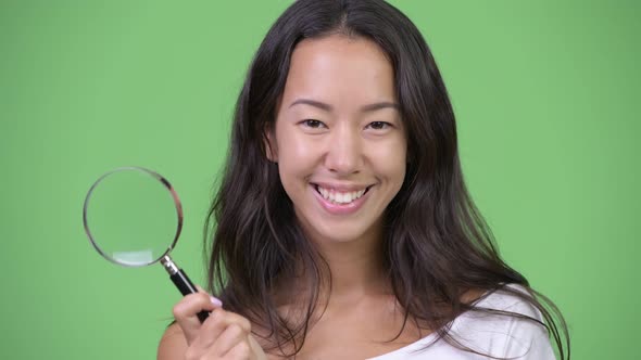 Young Happy Beautiful Multiethnic Woman Playing with Magnifying Glass