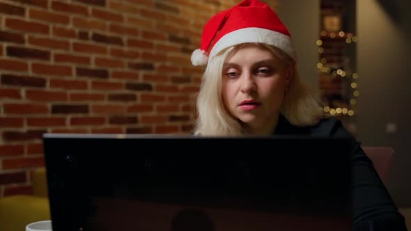 Adult 30s woman working at computer. Female person thinking then typing on laptop in home office alt