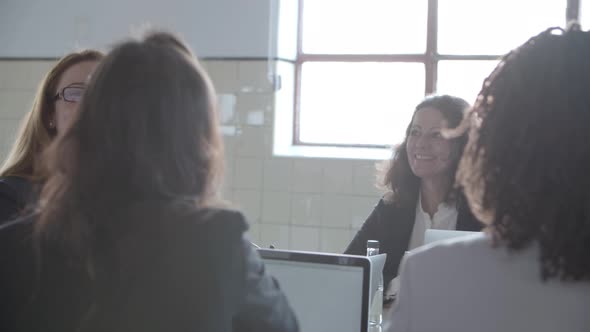 Content Businesswomen Discussing Project at Workplace alt