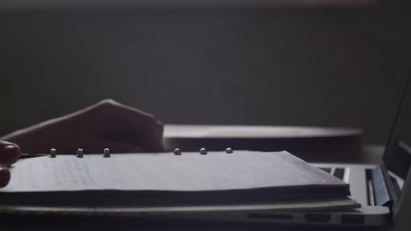 Closeup view hands put diary on laptop leaf through pages full of personal notes. Education concept. alt