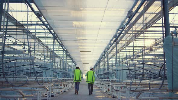 Engineers Walking Empty Factory Discussing Production Process Plan in Uniform alt