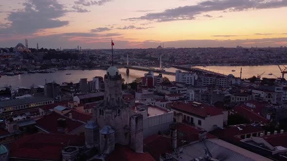 Aerial is flying sideways showing Galata Tower in Istanbul after sunset, Turkey alt