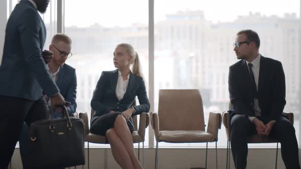 Young Candidates Waiting for Job Interview Sitting on Chairs in Reception Area alt