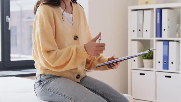 Female Patient Giving Papers to Doctor at Clinic alt