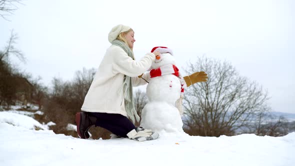 Girl Make Snowman Outdoor on Winter Day alt