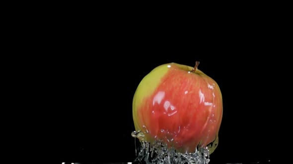Super Closeup of the Ripe Apple Bouncing From the Water with Splashes alt