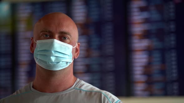 Middle-aged Man with Facial Mask in Airport or Station, Measures To Prevent Coronavirus Infection alt