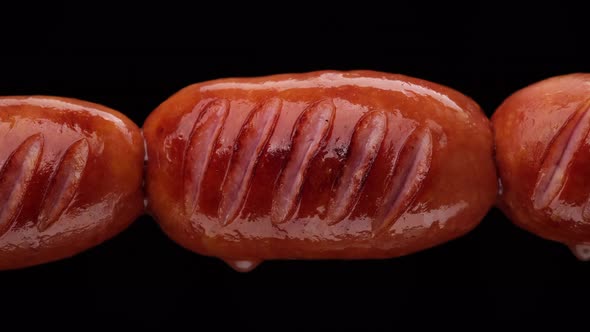 Fry sausages. Grilled sausages on black background alt