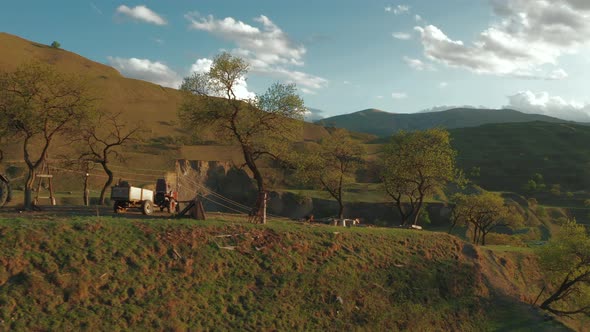 Aerial view of mountain hills, terraces on sunset, countryside landscape with tractor