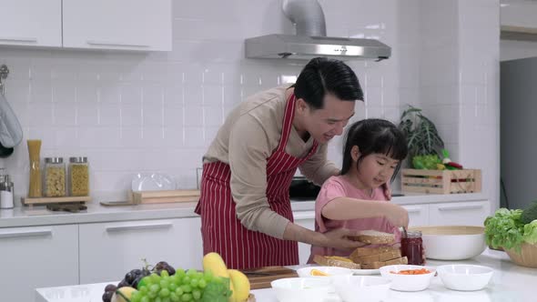 Father and daughter cooking in kitchen