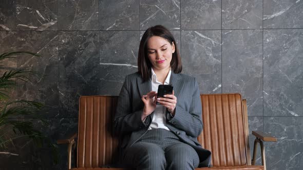 Businesswoman with Short Dark Hair Types on Black Smartphone alt