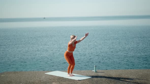A Woman Practices Yoga Alone on the Seashore