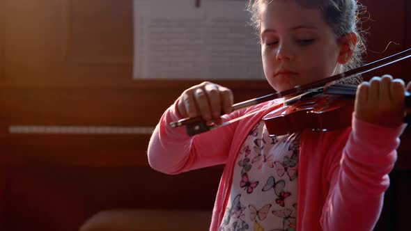 Schoolgirl playing violin in music class 4k alt