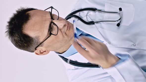 Vertical Shot Serious Doctor Takes Pen From His Pocket Writes Prescription on Clipboard