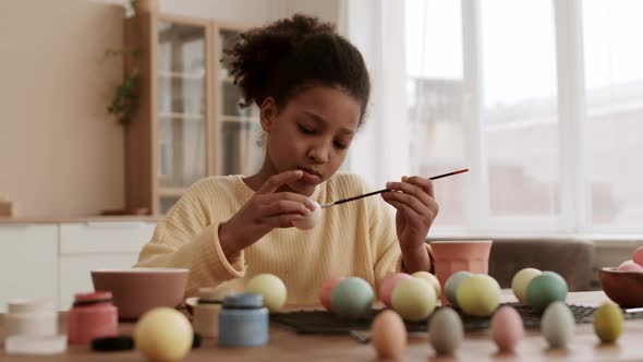 African Girl Coloring Eggs with Paint alt