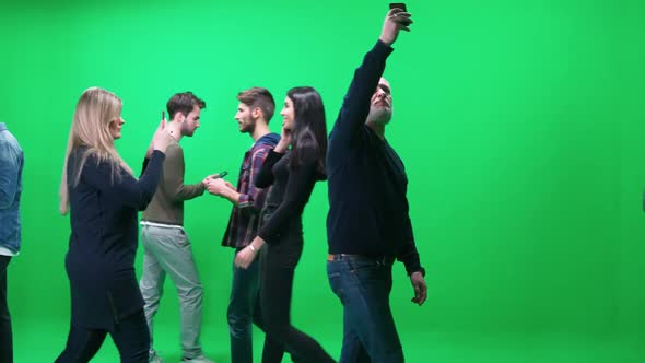 Crowd of People Walking Along the Road Using Smartphones and Talking on Mobile Phones on a Green alt