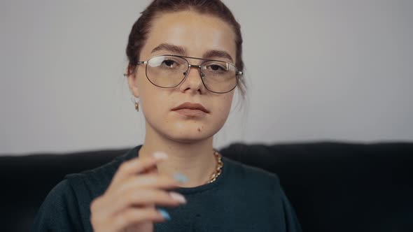 The Portrait of a Freckled Redhead with Her Hair Caught Wearing Her Glasses in Slow Motion alt