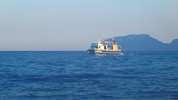 Boat Floats on Sea in Twilight, Mediterranean, Turkey, Mountains in Background